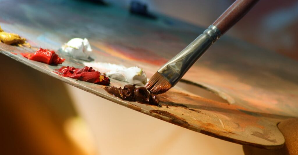 Vibrant artist palette with paint and brush creating colorful artwork.