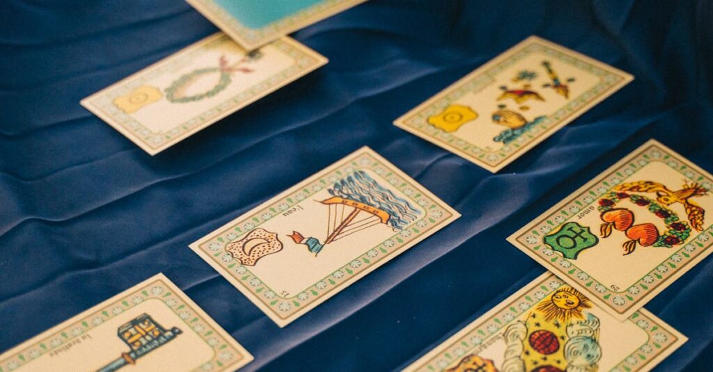 A close-up of tarot cards spread on a blue cloth with a hand selecting a card.